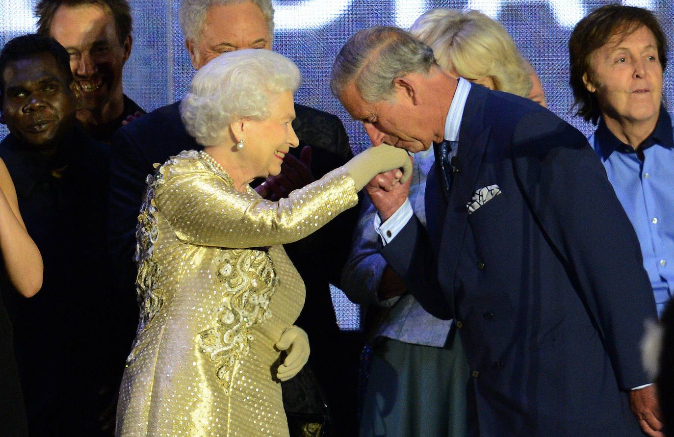 El príncipe Carlos besa la mano de su madre, la reina Isabel II de Inglaterra, durante un concierto.
