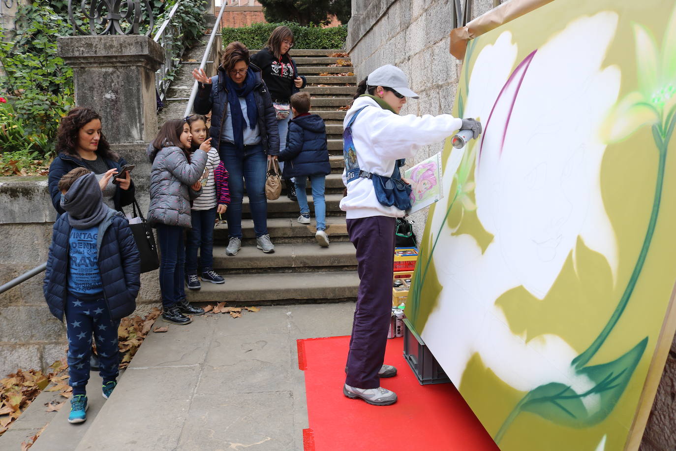 Una joven realiza un grafiti sobre un mural
