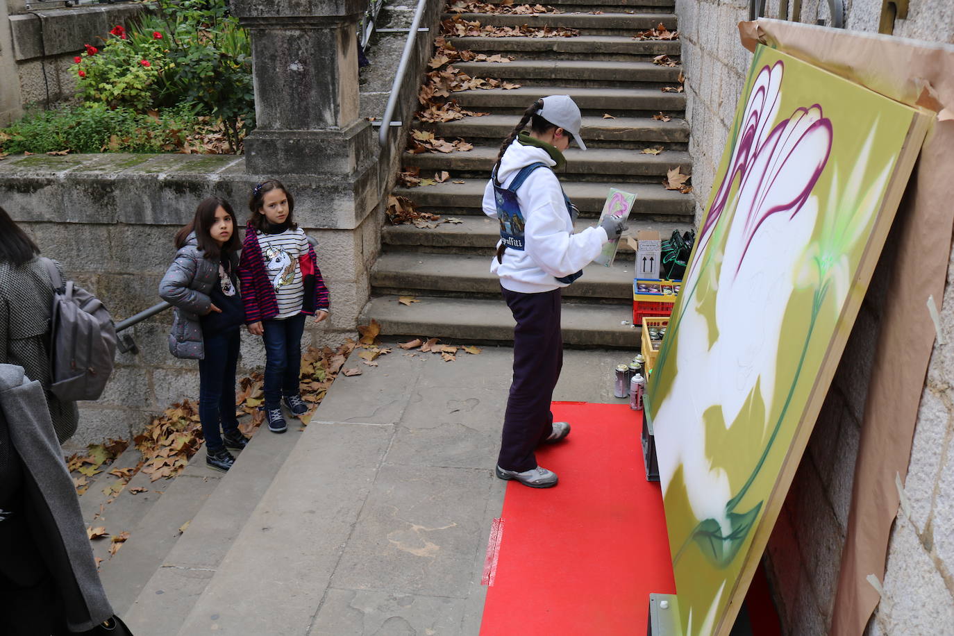 Una joven realiza un grafiti sobre un mural