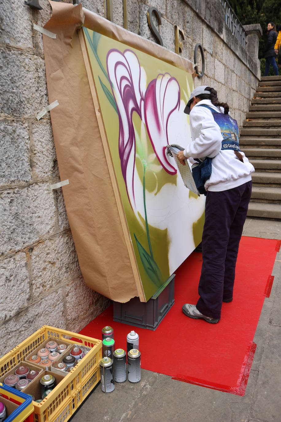 Una joven realiza un grafiti sobre un mural