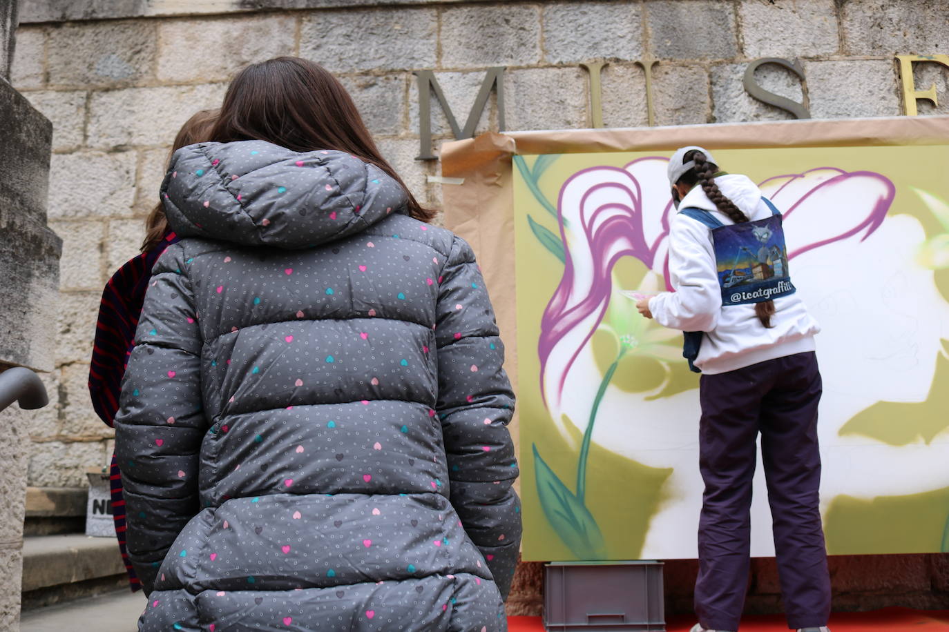 Una joven realiza un grafiti sobre un mural