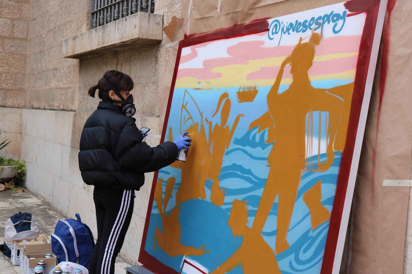 Una joven realiza un grafiti sobre un mural