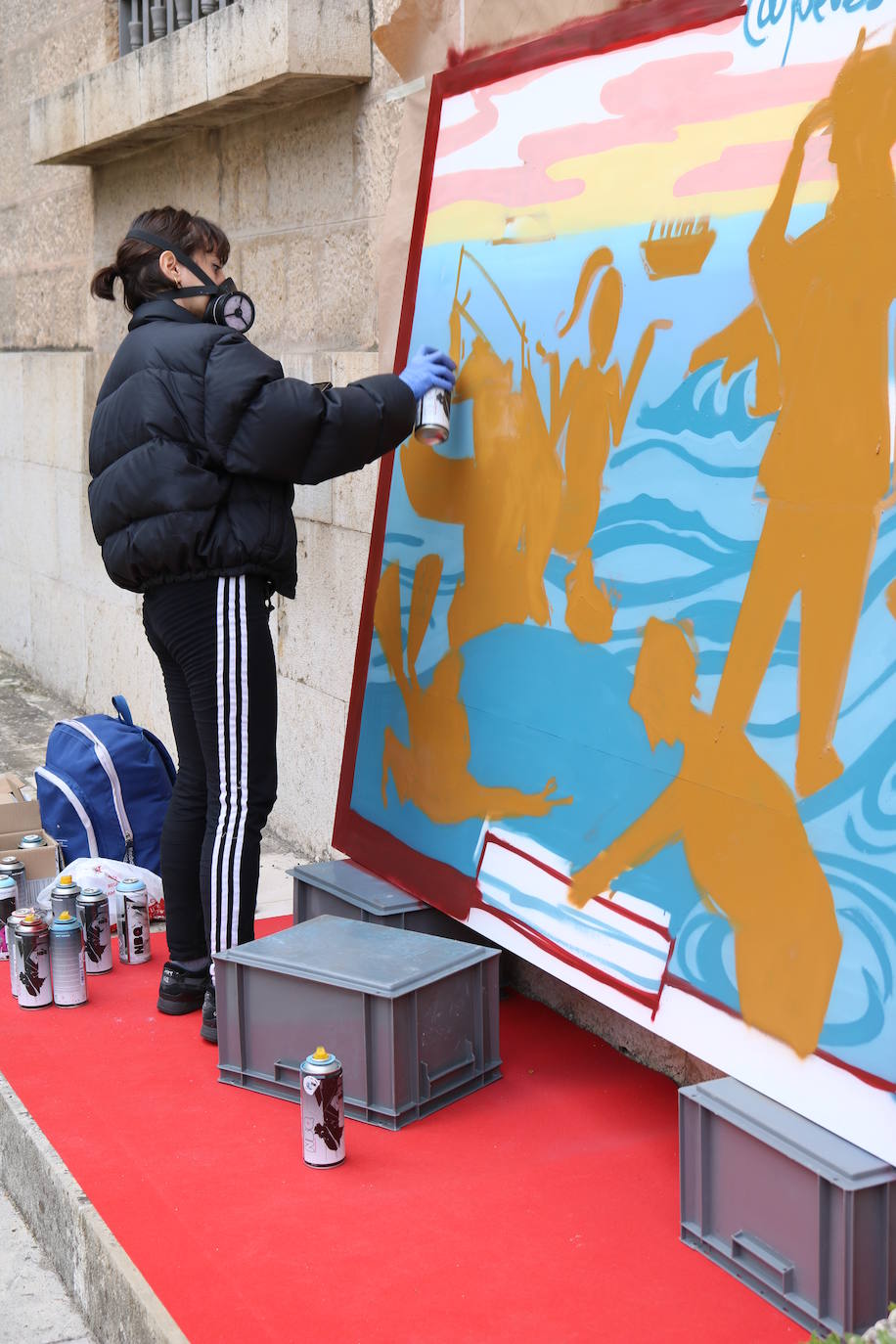 Una joven realiza un grafiti sobre un mural