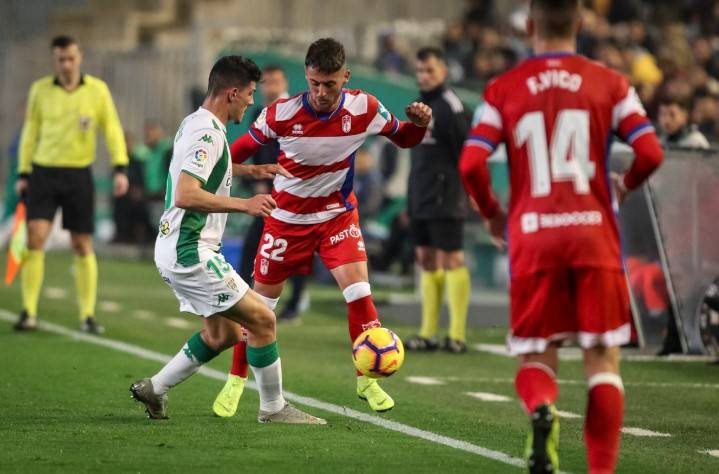Adri Castellano, ex del Córdoba, intenta marcharse de un rival ante la mirada de Fede Vico. 