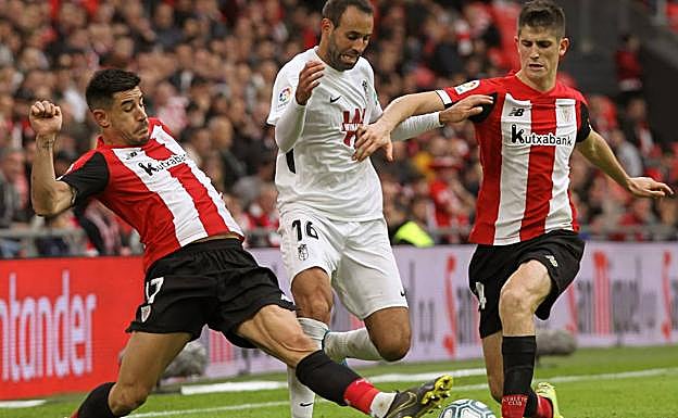 Víctor Díaz trata de sortear la presión de Yuri y Sancet. 