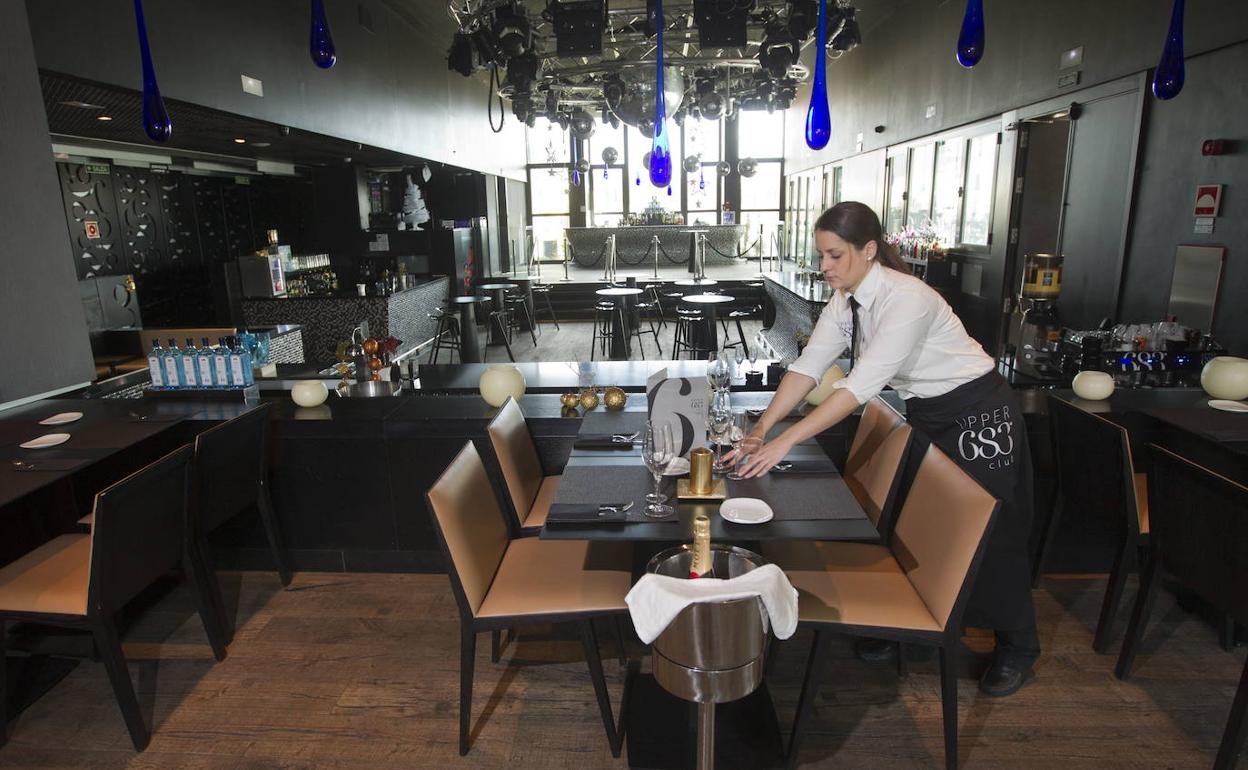 Una camarera prepara las mesas antes de la cena y el cotillón de Nochevieja. 