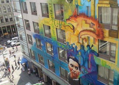 Imagen secundaria 1 - El Niño de las PInturas contempla su icónico mural en la Cuesta del Realejo, que necesita una restauración. El gato gordo y naranja se puede ver con Lorca en Manhattan. La Niña de las PInturas ha desaparecido ya, solo queda el pensador gigante en la calle Molinos.