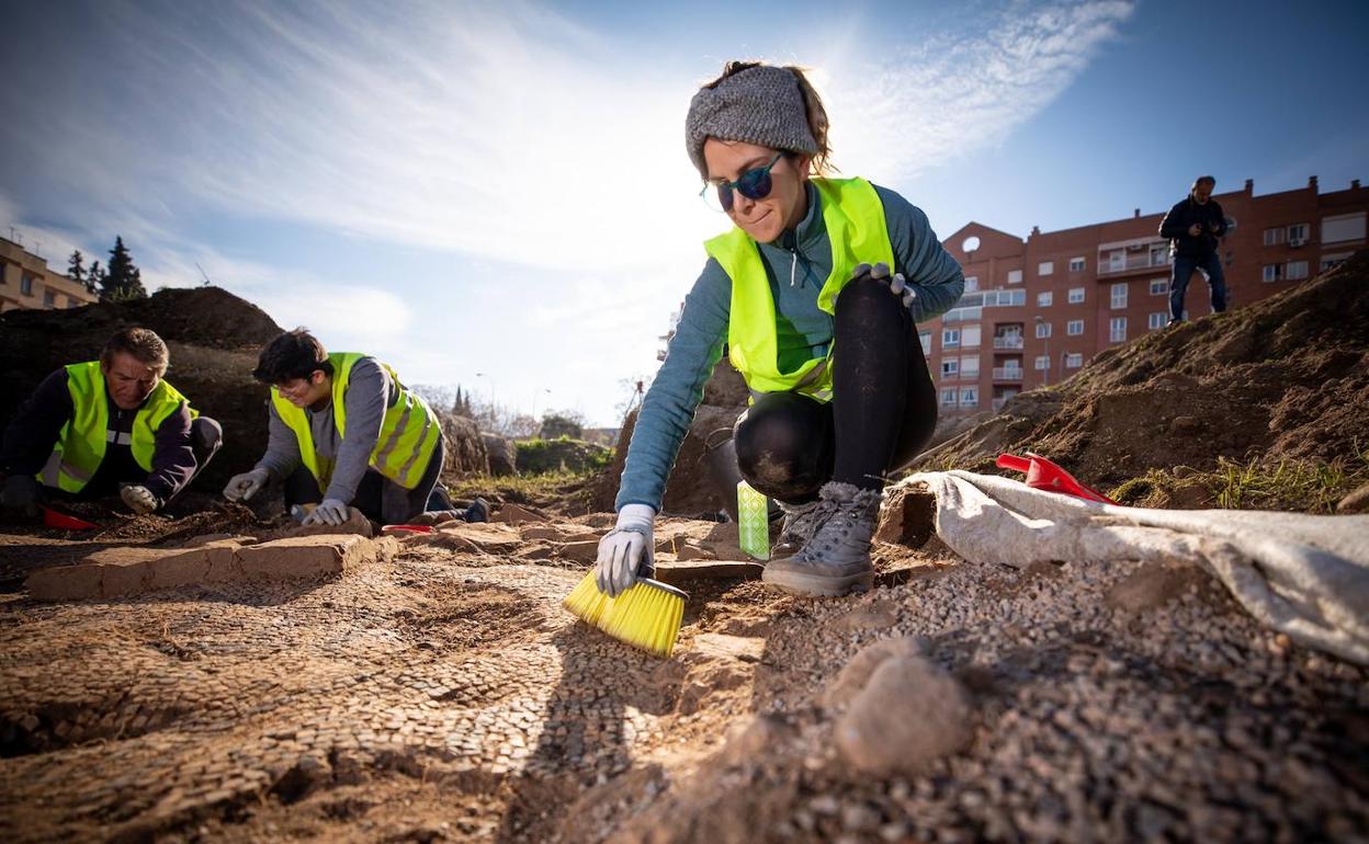 Arqueóloga cepilla restos de los primeros mosaicos que han aflorado en el solar donde se construirá la plaza Poeta Rafael Guillén.