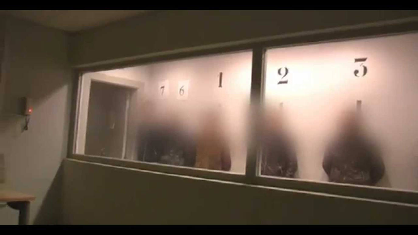 Una gruesa mampara de cristal que impide ver de un lado separa a la víctima de los participantes en la rueda de reconocimiento.