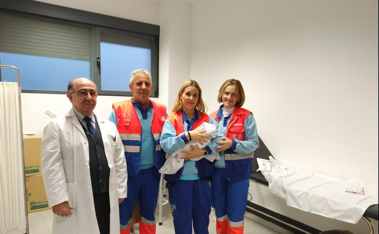Sanitarios que auxiliaron a la madre posan con el bebé.