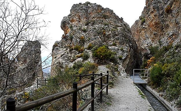 Galería. El sendero cruza entre rocas horadadas para que pase el agua 