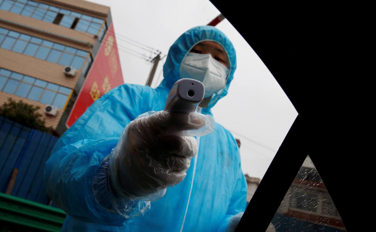 Un funcionario toma la temperatura a un conductor en la ciudad de Susong, en la provincia china de Anhui.
