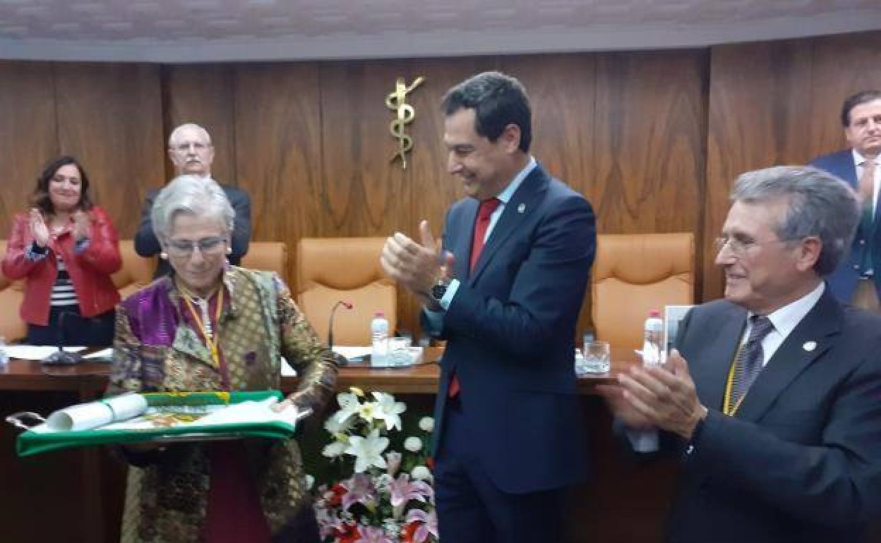 María Castellano recibiendo de manos del presidente Juanma Moreno la bandera de Andalucía. 