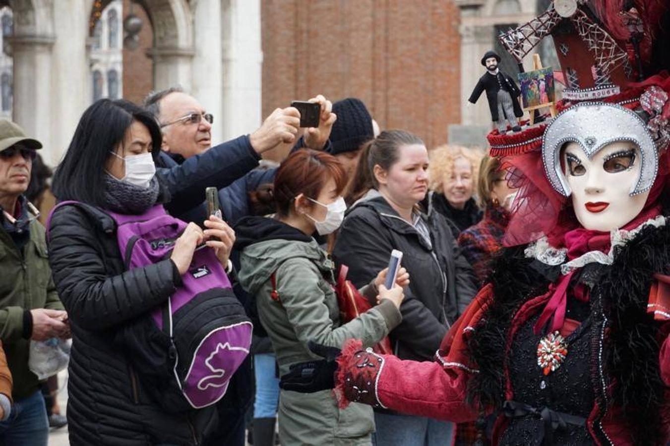 Turistas con máscaras protectoras visitan la Plaza de San Marcos, Venecia