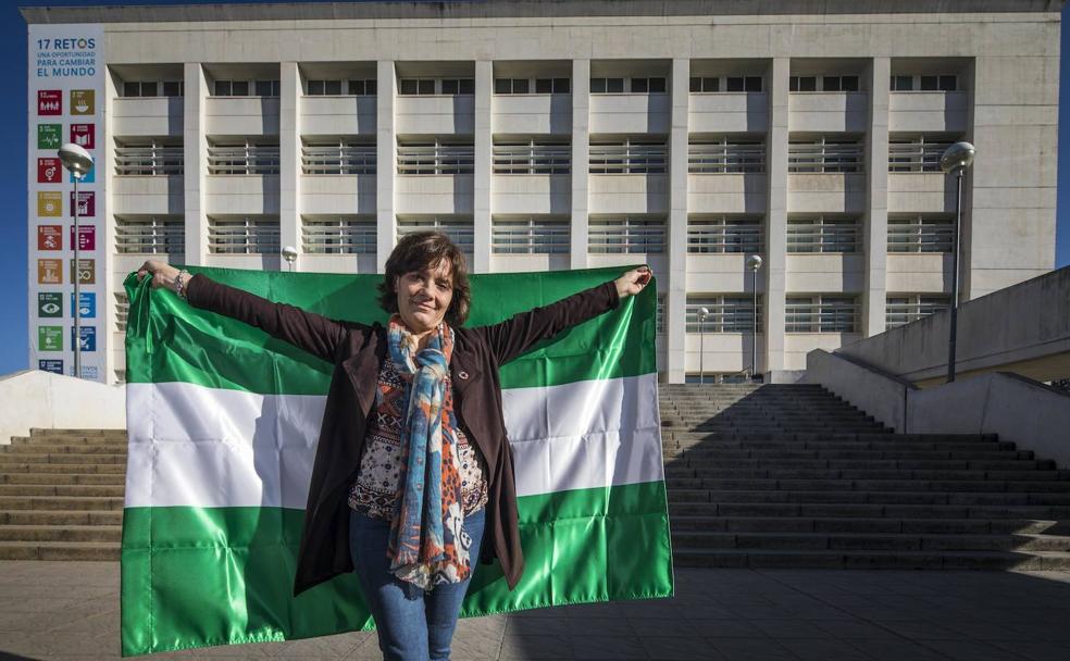 Montserrat Zamorano despliega una Bandera de Andalucía en la entrada de la Escuela de Ingeniería de Caminos de la UGR.
