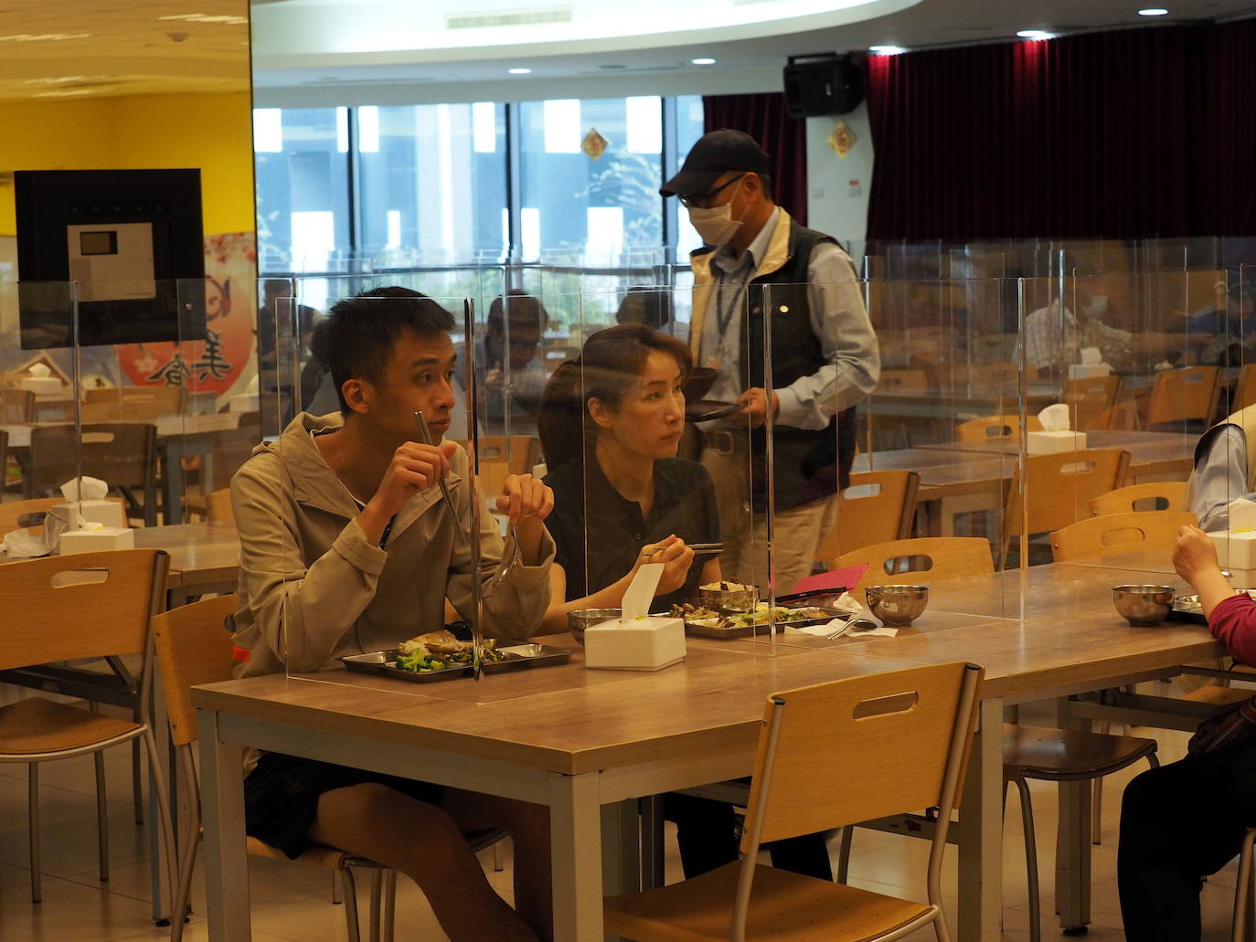 Trabajadores de Taiwan comiendo detrás de paneles para evitar el riesgo de contagio. 