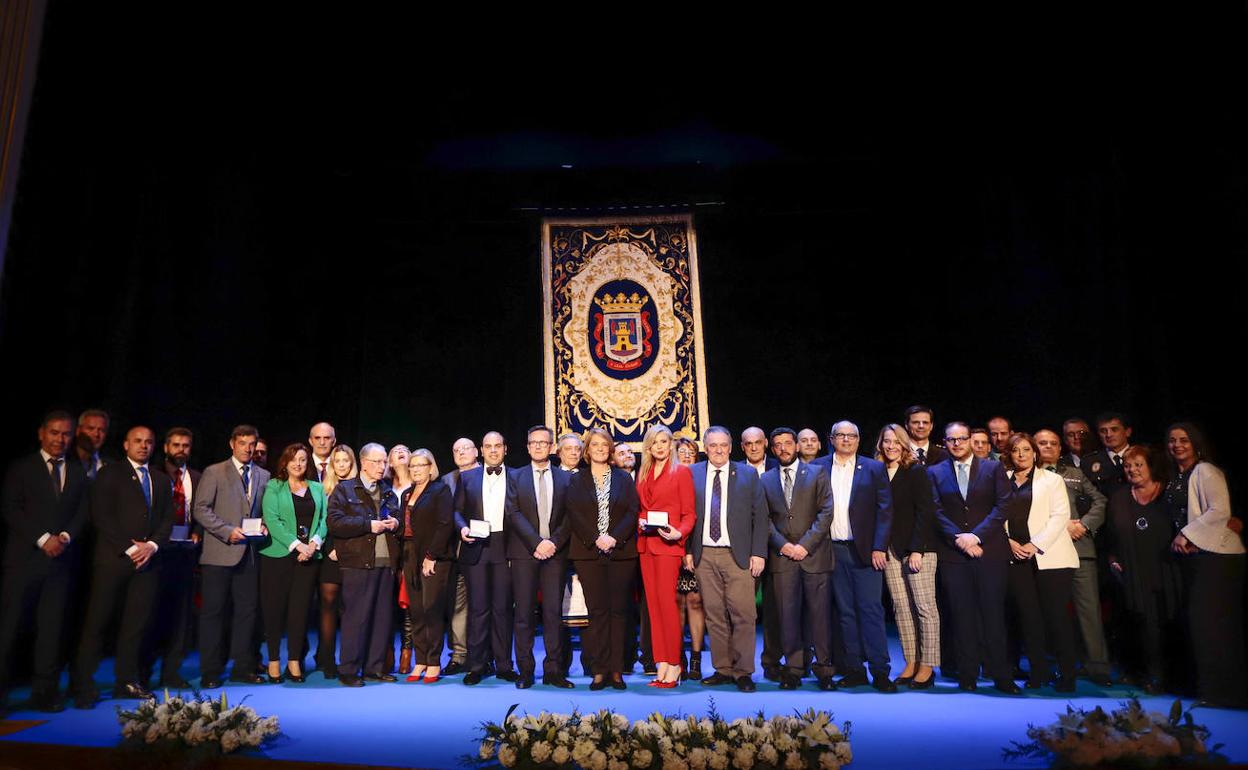 Los galardonados posan junto a parte de los miembros de la corporación municipal.