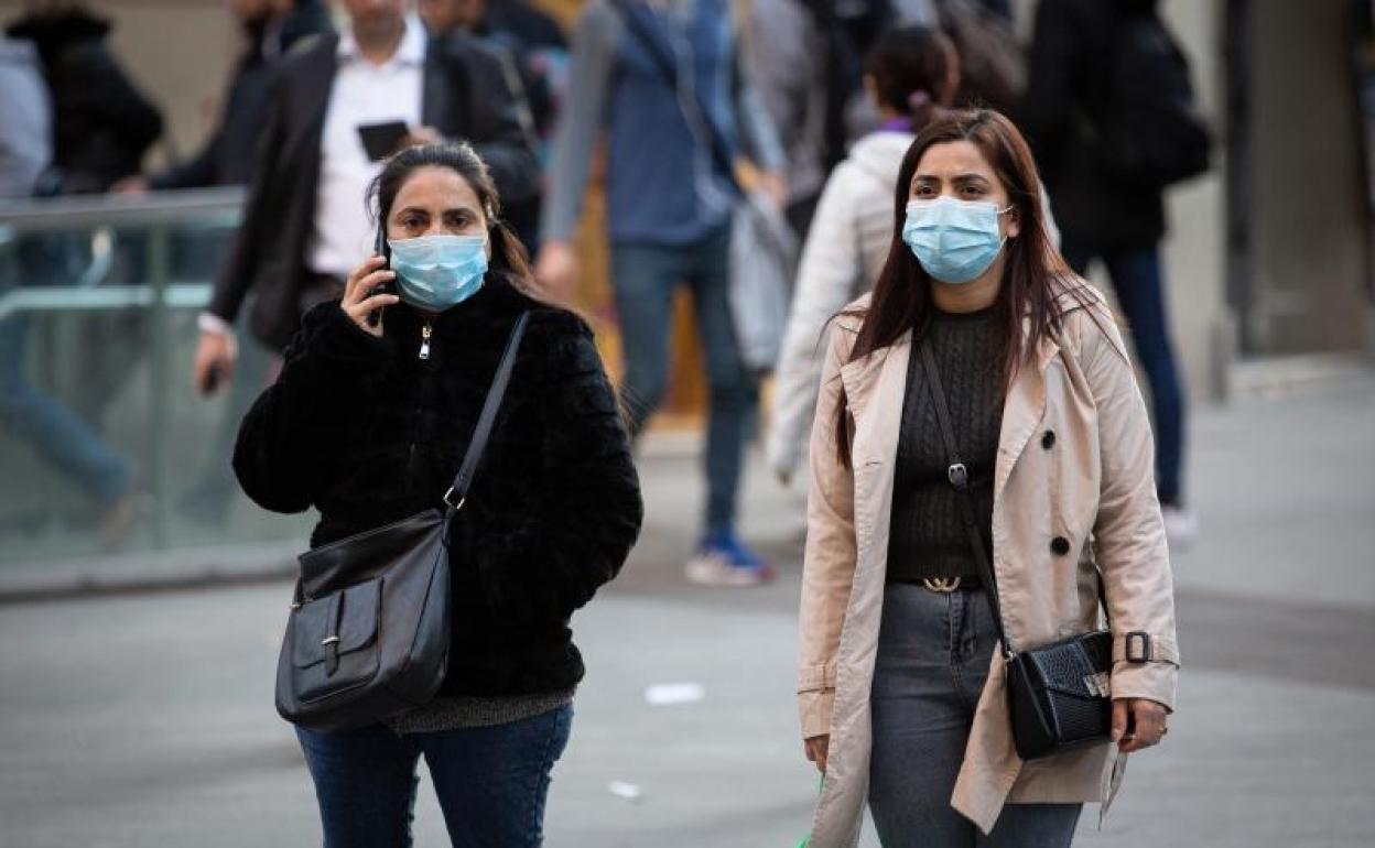 Transeúntes por el centro de Barcelona con mascarillas 