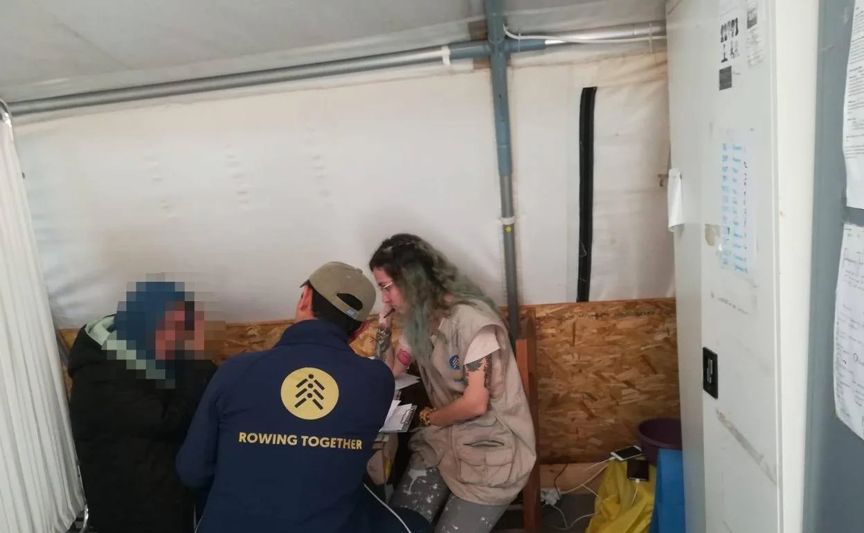 Dos voluntarios atienden a una mujer en un campo de refugiados de la isla griega de Lesbo