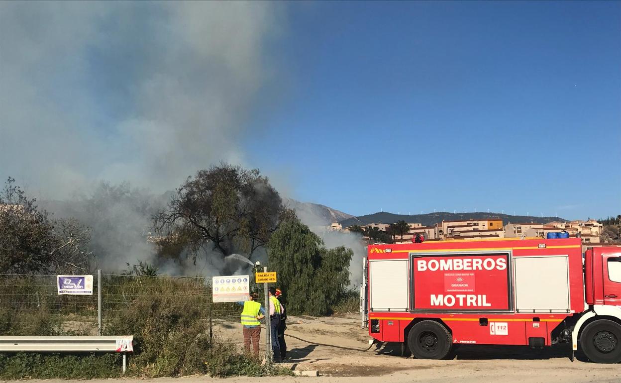 Los bomberos, sofocando el fuego de esta tarde.