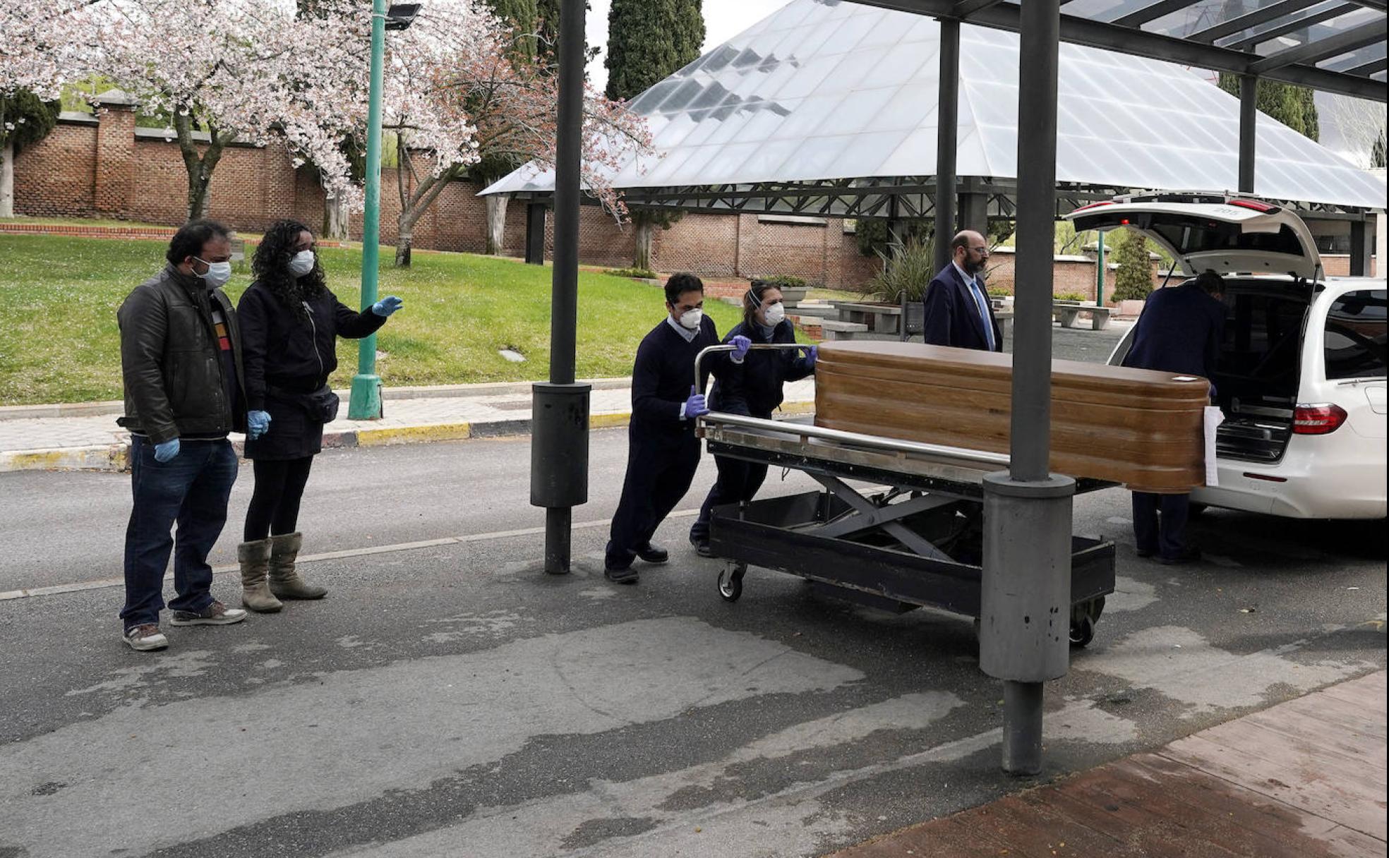 Los familiares acompañan a un ser querIdo muerto por el COVID-19 en el cementerio de La Almudena.