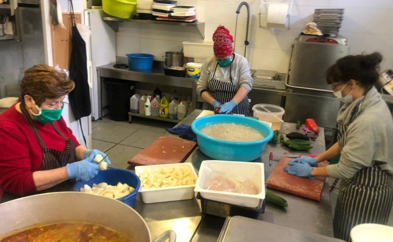 Mujeres preparan la comida solidaria del día en Casa Herminia