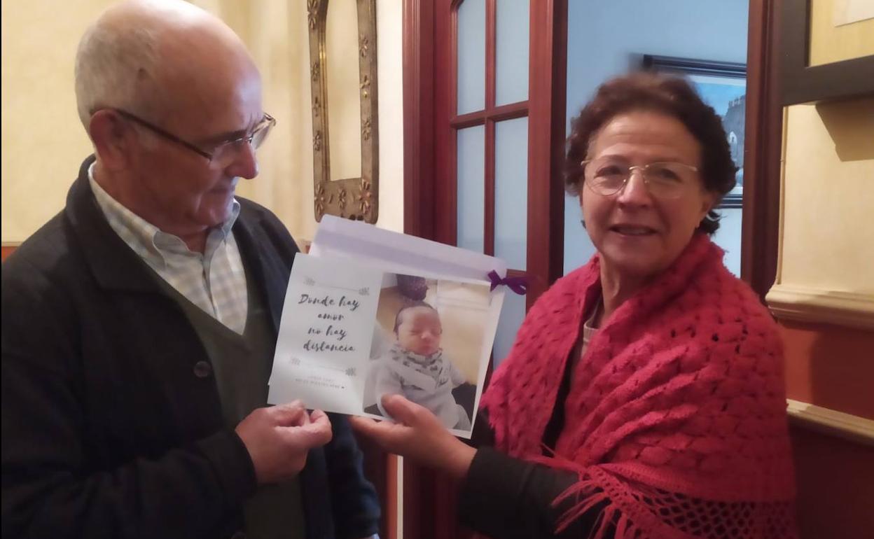 Una de las tías posa, junto a su marido y la foto de su sobrino-nieto. 