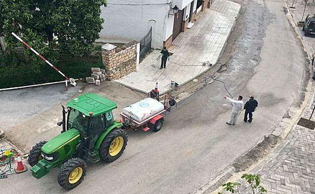 Voluntarios realizan tareas de desinfección en una calle de Cambil.