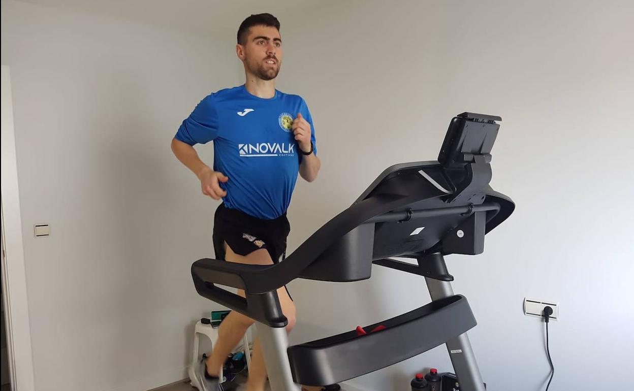 Pablo Sánchez, enfermero y atleta, corre sobre una cinta en su piso mientras se recupera del virus. 