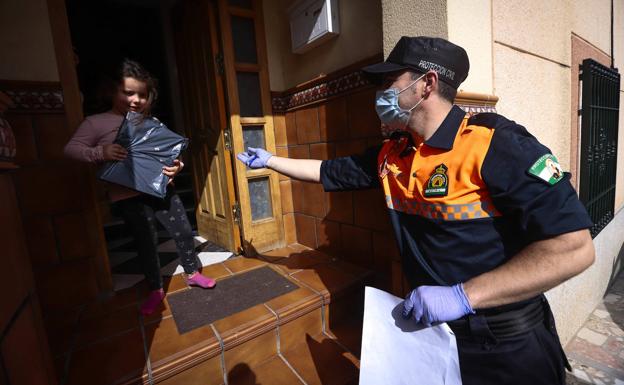 Los agentes de Protección Civil reparten los libros casa a casa.