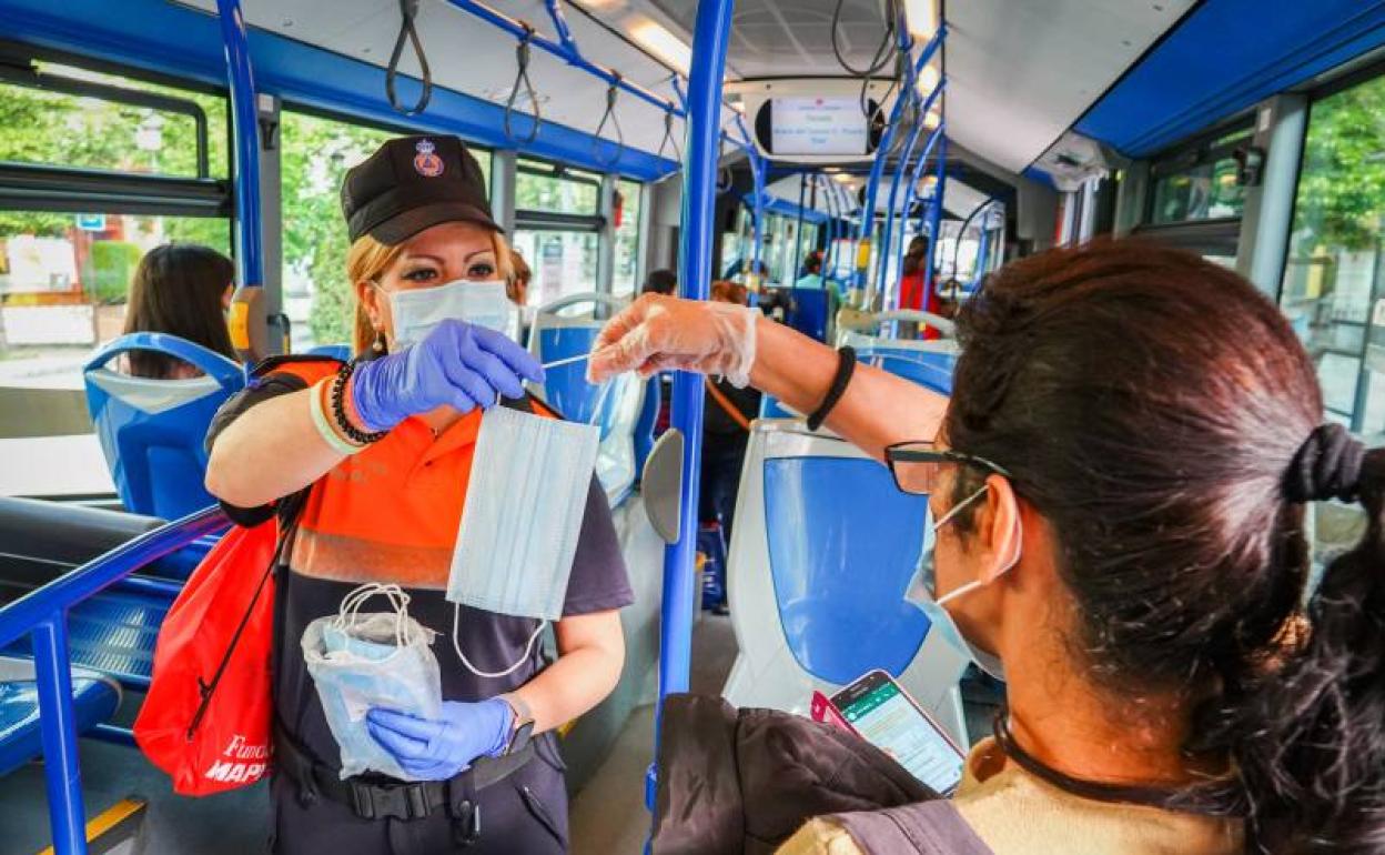 Berta Peinado, voluntaria de ProtecciónCivil, distribuye mascarillas en el interior de la línea 4.