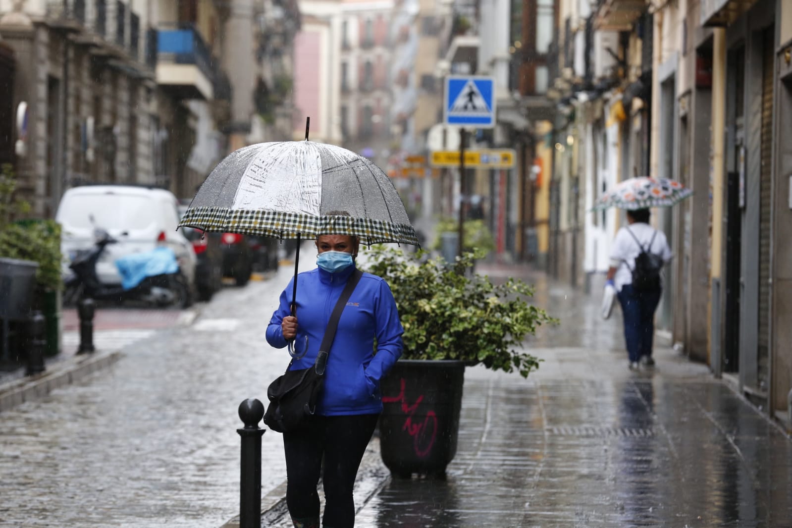El agua que está cayendo sobre a capital provoca que los granadinos que salen a la calle lo hagan protegidos
