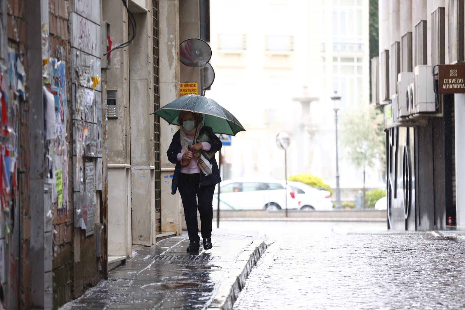El agua que está cayendo sobre a capital provoca que los granadinos que salen a la calle lo hagan protegidos
