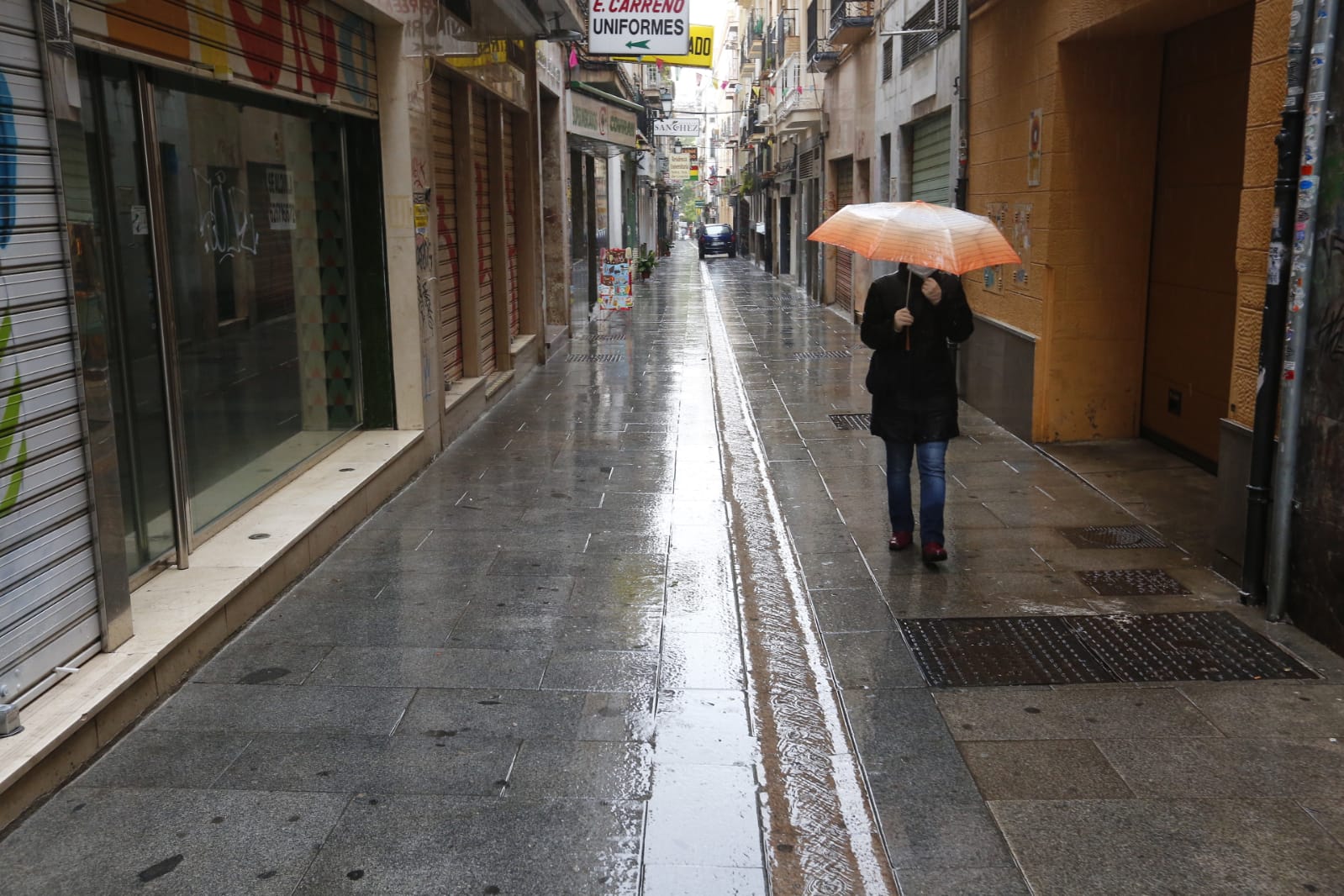 El agua que está cayendo sobre a capital provoca que los granadinos que salen a la calle lo hagan protegidos