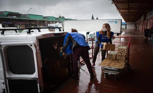 Voluntarios cargan la furgoneta de una asociación.