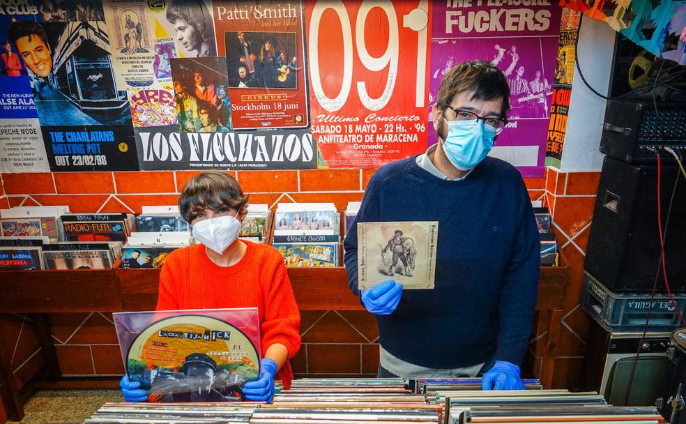 Mariajo y Gonzalo ordenan vinilos con los guantes puestos.