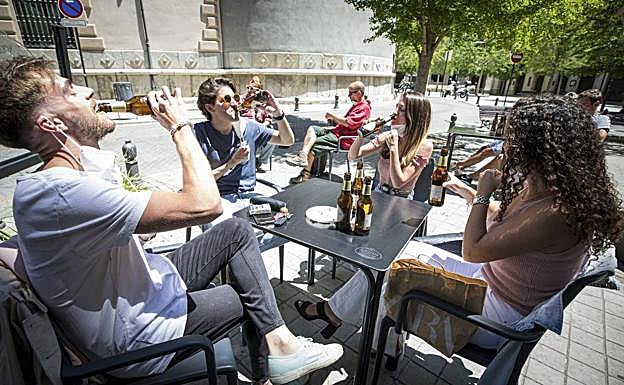 Unos jóvenes toman algo en una terraza del centro de Granada. 
