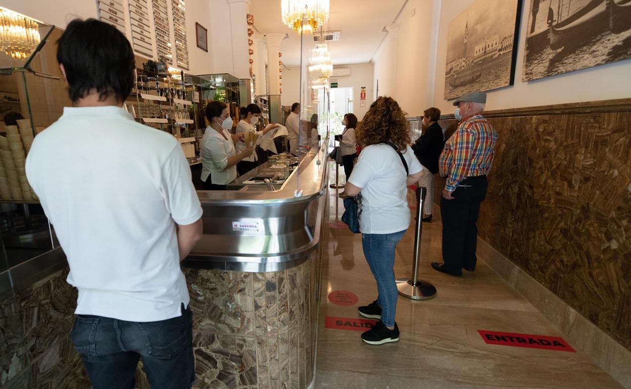 Varios clientes esperan a ser atendidos guardando la distancia de seguridad