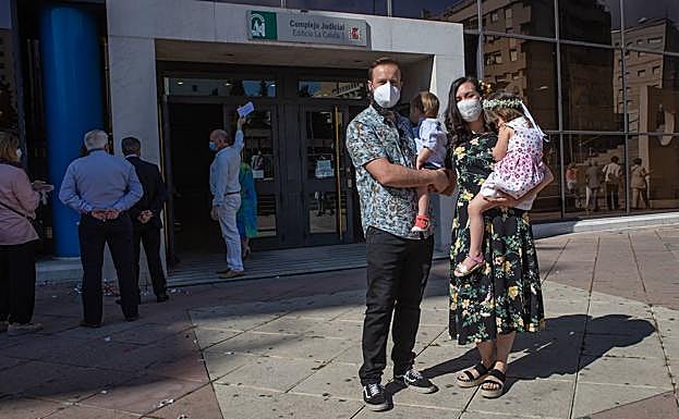 James y Cristina posan en la puerta de los juzgados con sus hijos Álex y Nora en brazos.