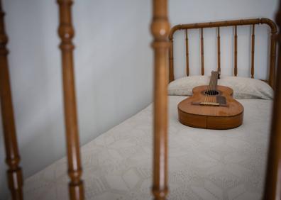 Imagen secundaria 1 - Arriba, detalle de la etiqueta donde vienen los datos del fabricante y año de fabricación. Abajo, la guitarra en la cama de Federico García Lorca.