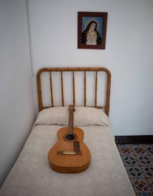Imagen secundaria 2 - Arriba, detalle de la etiqueta donde vienen los datos del fabricante y año de fabricación. Abajo, la guitarra en la cama de Federico García Lorca.