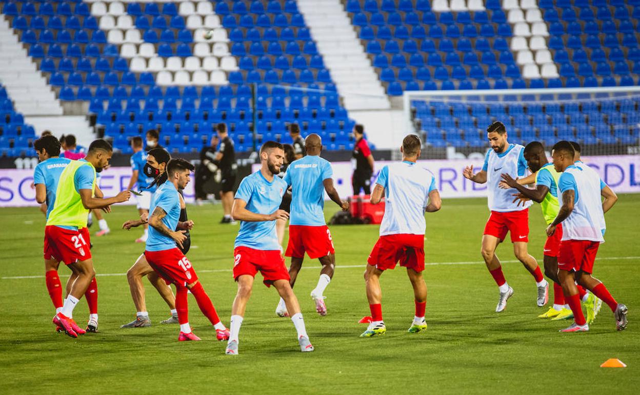 Los futbolistas del Granada calientan sobre el césped de Butarque. 