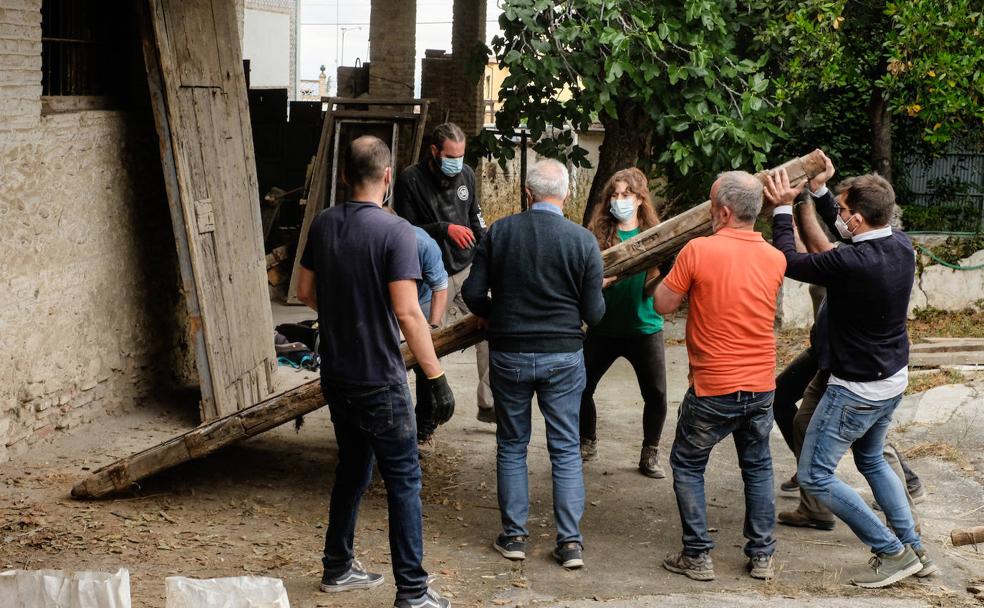 Voluntarios, junto con Cecilio Madero y Manuel Moral, colocan sobre una de las paredes de la fábrica el portón del siglo XVI que encontraron tras retirar maderas y escombros de la leñera. 