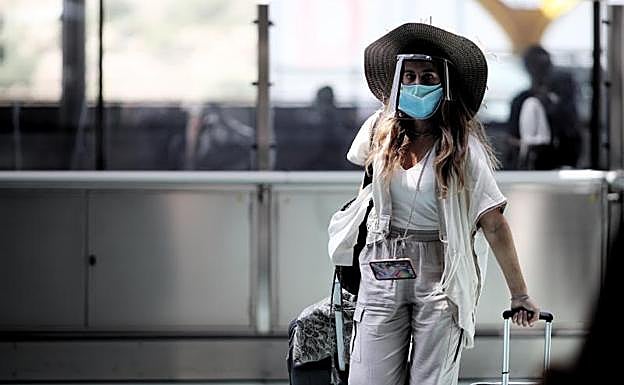 Una pasajera caminando con maleta por un pasillo de la terminar T4 del Aeropuerto Adolfo Suárez Madrid Barajas. 