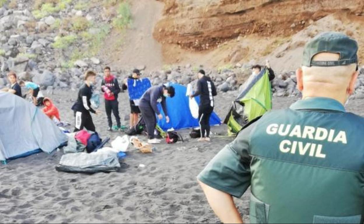 La Guardia Civil desalojando a los jóvenes que habían acampado en la playa. 