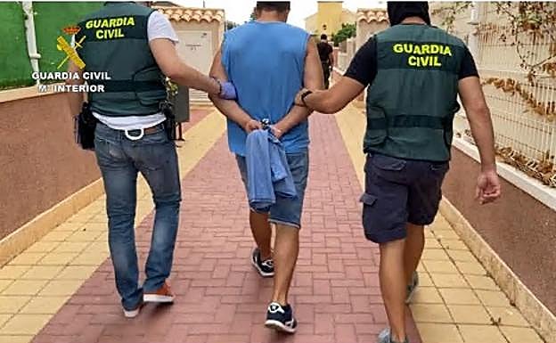 Agentes de la Guardia Civil conducen a uno de los detenidos.