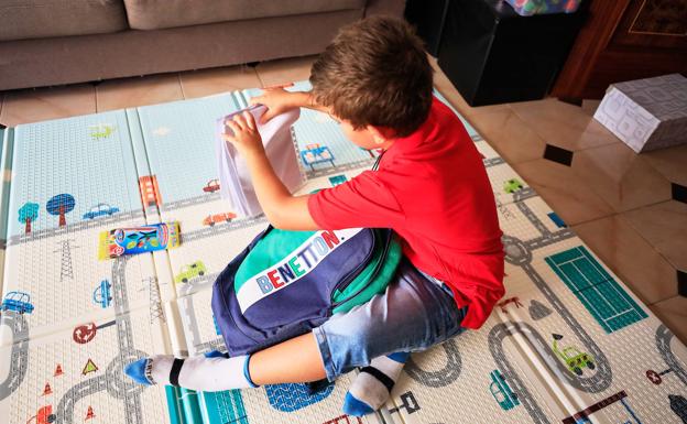 Manuel prepara su mochila para su primer día de colegio. 