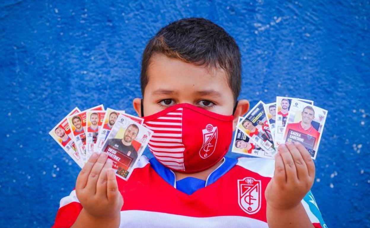 Un aficionado del Granada compara los cromos de su equipo con los del Athletic. 