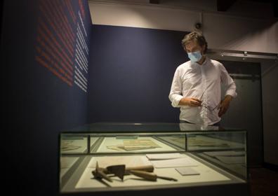 Imagen secundaria 1 - Arriba, inscripción gótica que había encima de la Puerta y que se guardaba en el Museo Arqueológico. Abajo, herramientas usadas en las excavaciones y uno de los cuadros de la exposición.