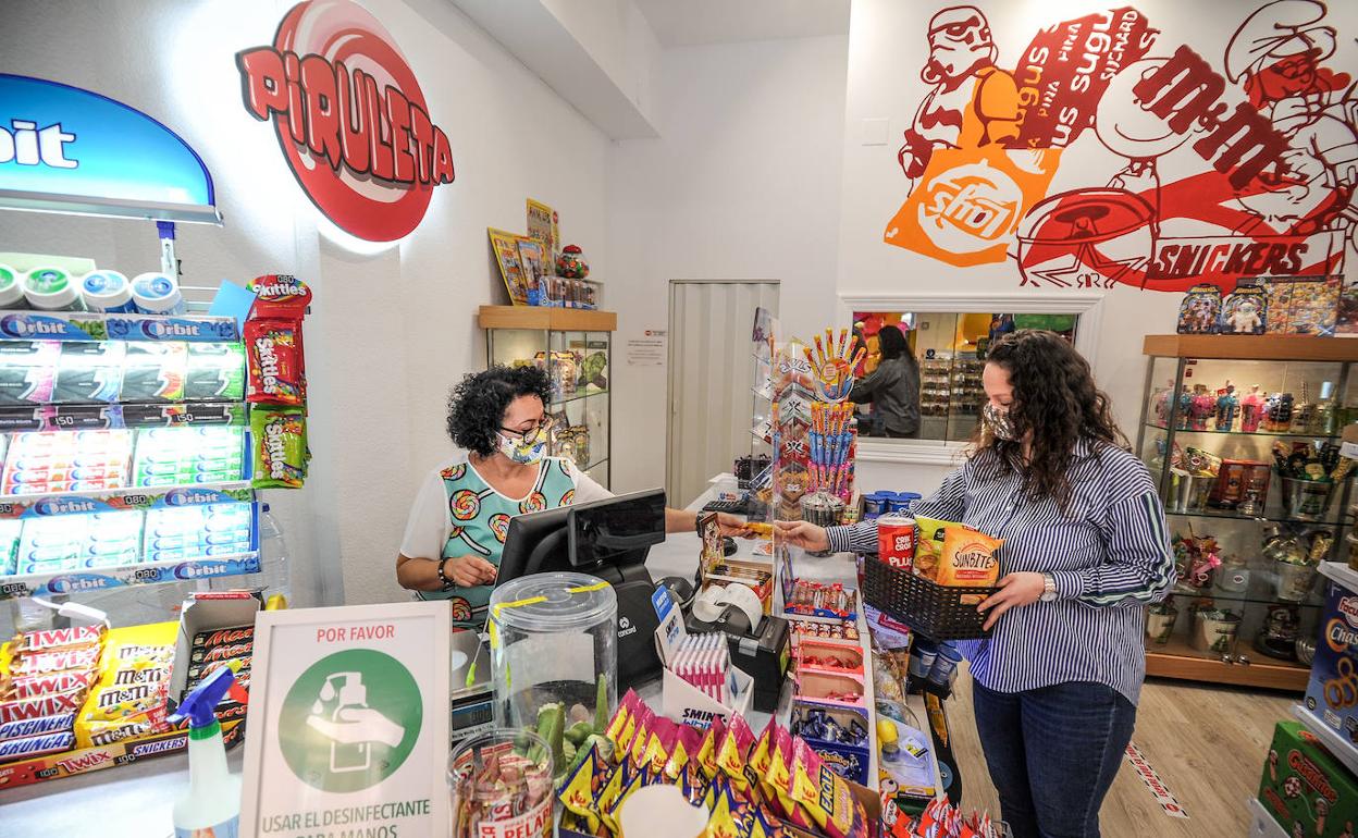 Ua autónoma atiende en su tienda de chucherías. 